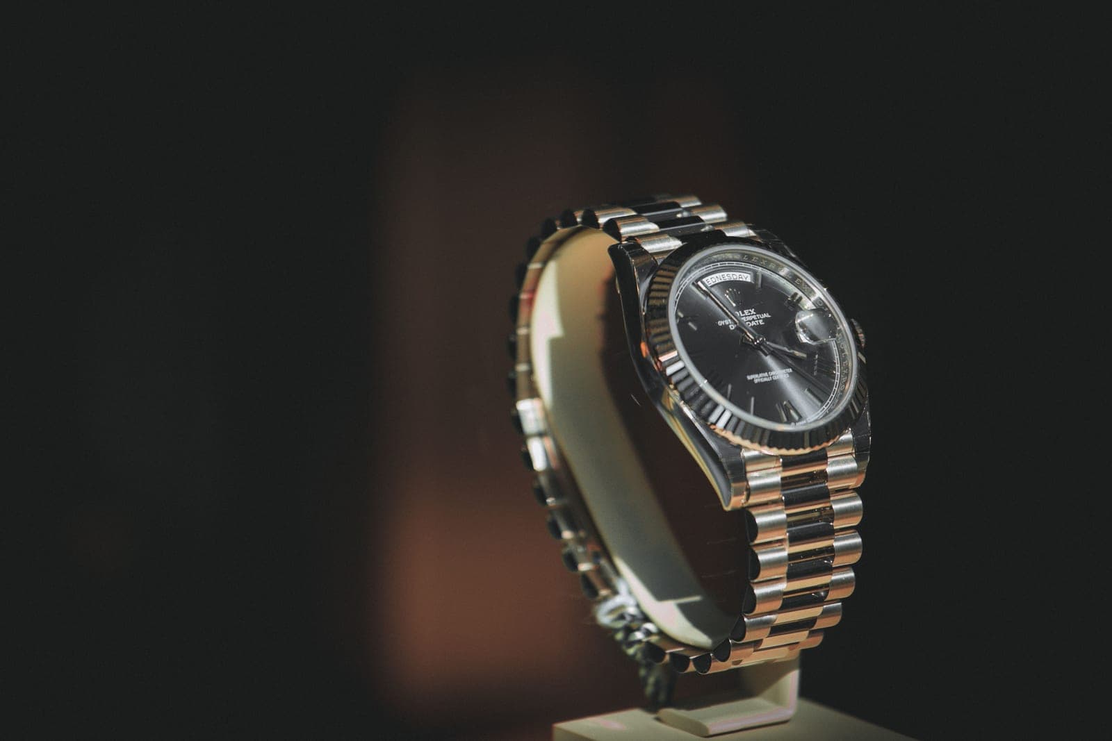 Close-up of an automatic watch dial and hands in warm, low light